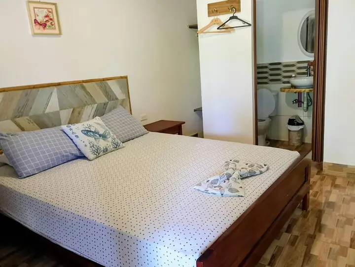 Habitación con cama doble y cabecera de madera